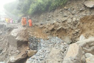क्षतिग्रस्त मार्ग को ठीक करने में जुटे मजदूरों पर खराब मौसम की मार